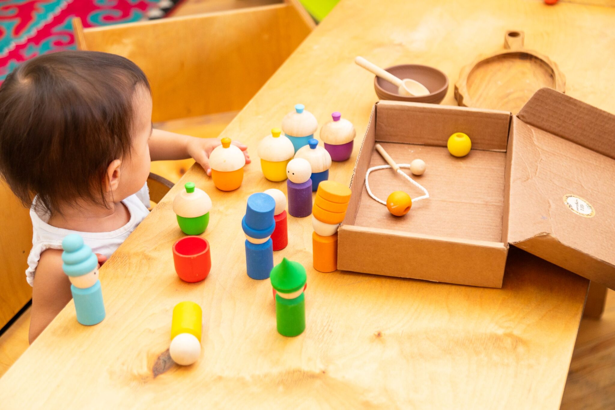 toddler-girl-playing-with-peg-dolls-with-cups-and-2025-03-31-03-14-56-utc